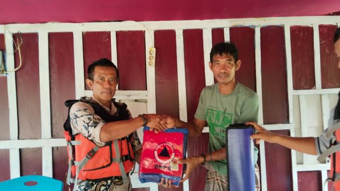 Personel BPBD Pasangkayu saat memberikan bantuan kepada warga terdampak banjir