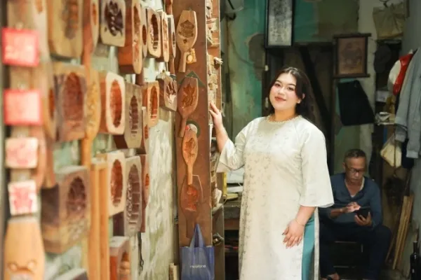 Monica Niebrit, 26, of the U.S., poses for photos at a traditional wooden mould workshop on Hang Quat Street, Hoan Kiem Ward, Hanoi, December 2025. Photo courtesy of Niebrit