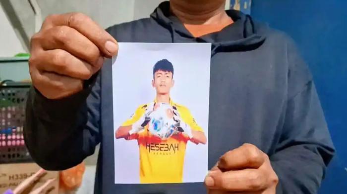 BUKAN KORBAN TPPO - Ayahanda Riski Nur Fadhilah, Dedi Solehudin sedang memegang foto anaknya, Riski Nur Fadhilah (18). Rizki dipastikan bukan korban tindak pidana perdagangan orang atau TPPO di Kamboja, Jumat (21/11/2025).