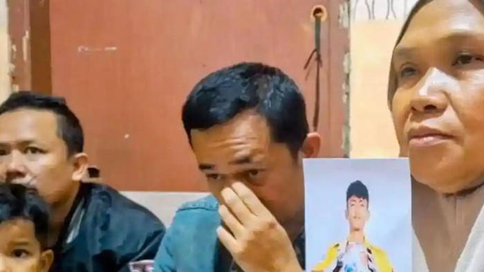 Imas Siti Rohanah (52) warga Kelurahan Pesawahan, Kecamatan Dayeuhkolot, Kabupaten Bandung, menunjukkan foto cucunya, Rizki Nur Fadhilah, Selasa (18/11/2025). Paman korban tiap hari salat tahajud agar keponakan cepat pulang ke Indonesia. (Tribun Jabar/Adi Ramadhan Pratama)