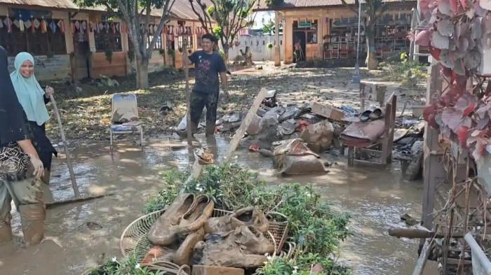 SEKOLAH TERDAMPAK BANJIR – Kepala sekolah bersama guru melakukan pembersihan lumpur di SDN 2 Kutablang, Bireuen, Aceh, pasca-banjir Sumatera, Kamis (11/12/2025). Pemerintah menyiapkan Rp13,3 miliar, sementara solidaritas akademik tumbuh menjaga ekosistem belajar tetap berjalan.