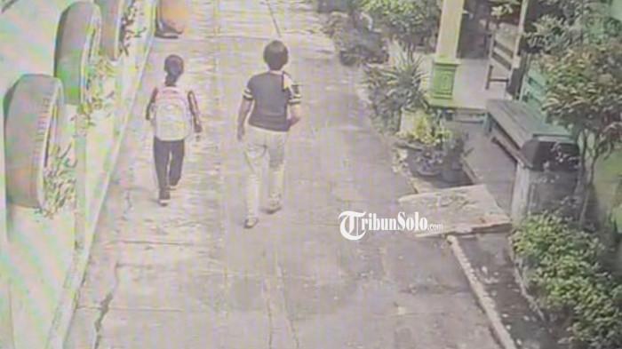 RAMPAS ANTING - Tangkapan layar rekaman cctv pelaku perampasan anting siswi kelas 1 di SDN 3 Jaten, Karanganyar, Jumat (9/1/2026) kemarin. Pelaku wanita itu menghampiri korban dan meminta melepas anting korban. Pelaku mengaku akan menculiknya jika korban tidak melepas antingnya.