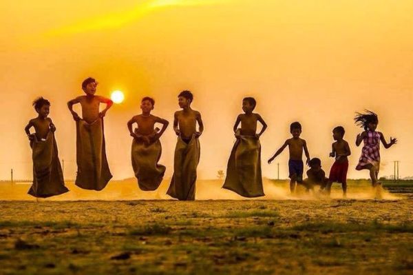 This may contain: a group of people standing on top of a grass covered field next to each other