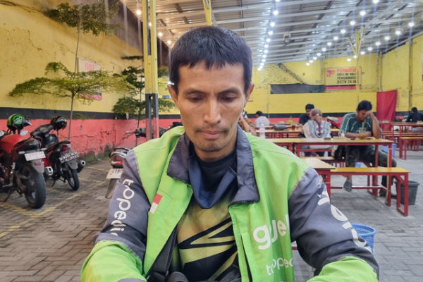 Driver ojek online di Surabaya, Ambar Wanto, yang belajar bahasa Inggris dan direkam saat menunggu orderan. Foto: Farusma Okta Verdian/kumparan