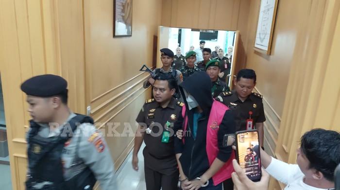 DIGIRING PETUGAS -- Aditya Rizki Pradana tampak digiring keluar dari Gedung Kejaksaan Negeri Bangka Selatan dengan pengawalan ketat petugas, Rabu (14/1/2026) malam. Aditya Rizki Pradana resmi ditetapkan sebagai tersangka tindak pidana korupsi SP3AT fiktif.