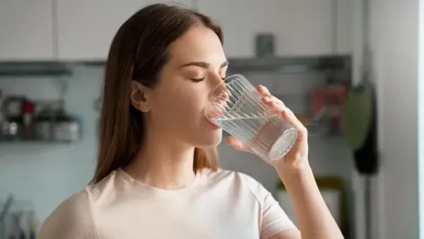 woman drinking water with her eyes closed