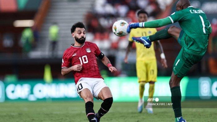 Penyerang Mesir #10 Mohamed Salah (Kiri) berebut bola dengan kiper Mozambik #1 Ernan Siluane (kanan) selama pertandingan sepak bola grup B Piala Afrika (CAN) 2024 di Stadion Felix Houphouet-Boigny, pada 14 Januari 2024.FRANCK FIFE / AFP