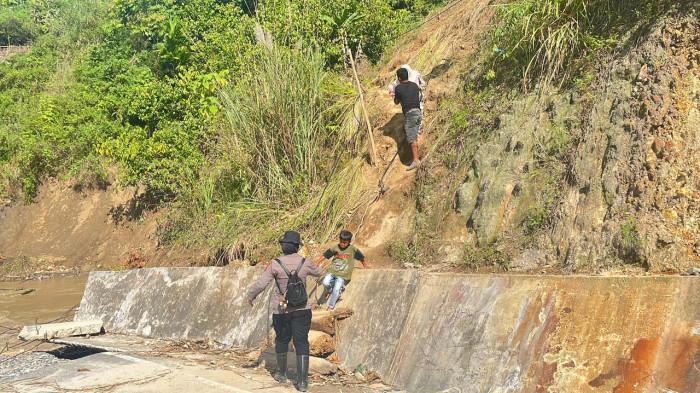 BANTU WARGA - Seorang Polisi Wanita (Polwan) dari Polres Aceh Tenggara membersamai para korban banjir dan tanah longsor di Kecamatan Ketambe, Kabupaten Aceh Tenggara, beberapa waktu lalu. Mereka membantu masyarakat yang membutuhkan hingga memberikan trauma healing kepada anak-anak korban bencana.