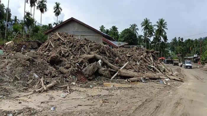 KAYU MENUMPUK - Material banjir bandang batu dan kayu gelondongan menumpuk di lokasi banjir bandang Kecamatan Ketambe, Aceh Tenggara, Kamis (8/1/2026). Material bebatuan dan tanah masih menempel di pemukiman penduduk.