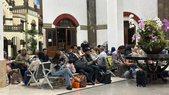 TERTAHAN - Para calon penumpang tertahan di ruang keberangkatan menunggu normalisasi jalur kereta api di Stasiun Semarang Tawang, Kamis (15/1/2026). KA yang hendak mereka naiki belum bisa diberangkatkan lantaran jalur tergenang banjir di Kaliwungu-Kalibodri Kabupaten Kendal.