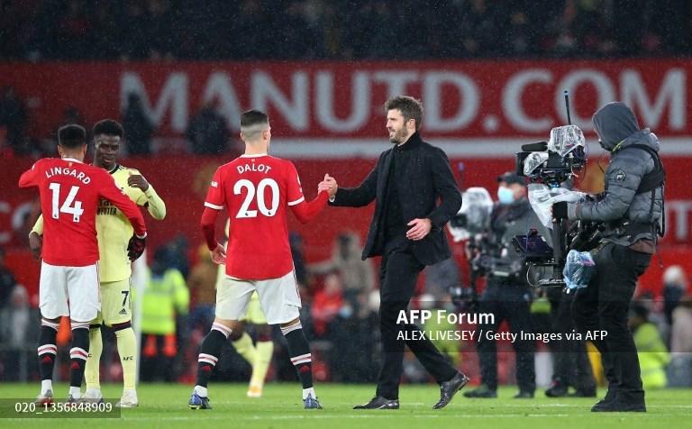 Diogo Dalot dari Manchester United berjabat tangan dengan Michael Carrick, Manajer Interim Manchester United setelah pertandingan Liga Inggris antara Manchester United dan Arsenal di Old Trafford pada 02 Desember 2021 di Manchester, Inggris. (Foto oleh Alex Livesey/Getty Images)