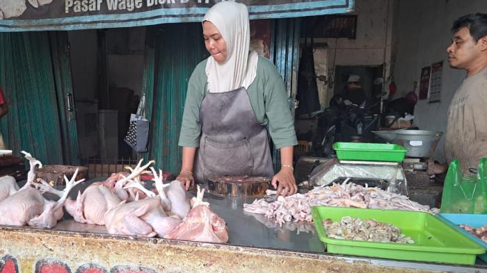 MULAI TURUN - Pedagang daging ayam di Pasar Wage Purwokerto menanti pembeli, Selasa (16/12/2025).