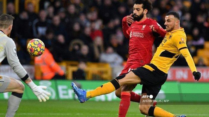 WOLVES BERPOTENSI IMBANG - Gelandang Wolverhampton Wanderers asal Maroko Romain Saiss (kanan) melawan gelandang Liverpool asal Mesir Mohamed Salah (tengah) dalam pertandingan sepak bola Liga Inggris antara Wolverhampton Wanderers dan Liverpool di stadion Molineux di Wolverhampton, Inggris tengah pada 4 Desember 2021.