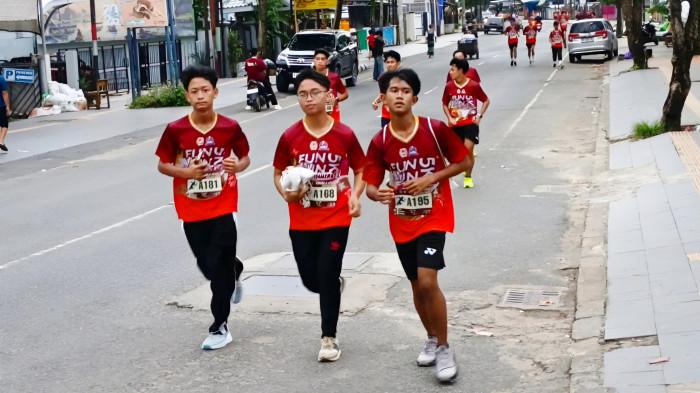 Pengalungan medali fun run 5 km kepada para peserta, yang telah berhasil mencapai garis finish