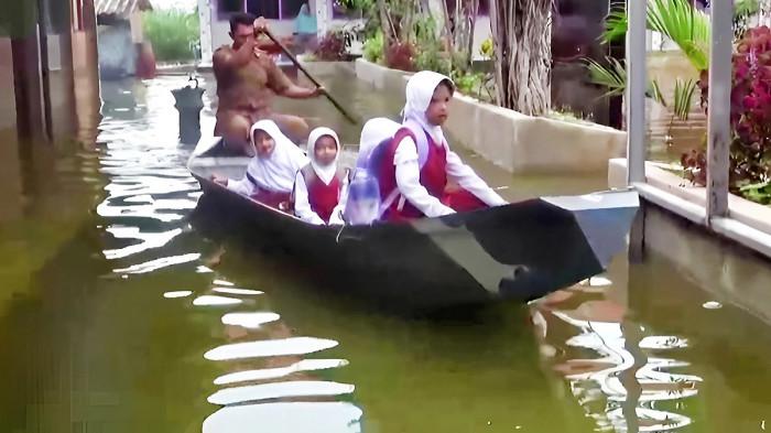 BANJIR LAMONGAN - Guru SDN Jelak Catur menjemput para siswa menggunakan perahu akibat banjir luapan Sungai Bengawan Jero yang kian meluas di Kabupaten Lamongan, Jawa Timur, Selasa (13/1/2026). Langkah ini dilakukan, agar kegiatan belajar mengajar tetap terlaksana, ruang kelas masih aman untuk digunakan, namun akses menuju sekolah sudah tidak bisa dilalui dengan berjalan kaki.