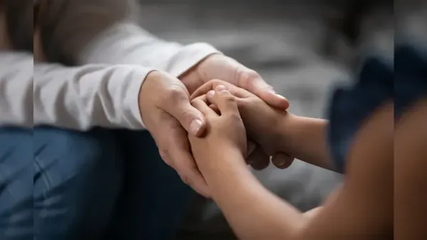 Parent comforting a child through gentle touch