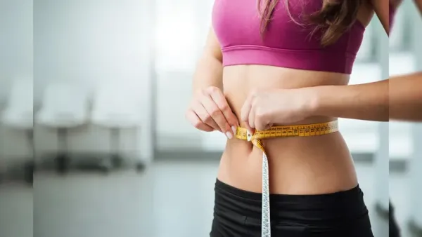woman measuring her waist with inch tape