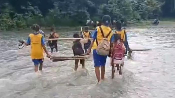 TAK DIGUBRIS - Para siswa melintasi banjjr kali Lowolaka Ende saat ke sekolah. Ternyata ibu hamil juga menjadi korban sulitnya melintasi sungai padahal keadaan darurat akan melahirkan.