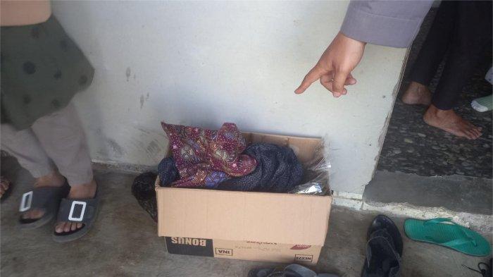 PENEMUAN BAYI- Petugas kepolisian menunjuk kardus makanan ringan di lokasi penemuan bayi dengan jenis kelamin perempuan di Jorong Pandam Gadang Ranggo Malai (PGRM), Nagari Gadut, Kecamatan Tilatang Kamang, Kabupaten Agam, Kamis (15/1/2026).