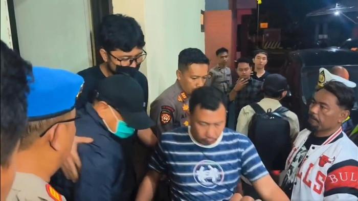 TINGGALKAN POLRES KUDUS - Bupati Pati Sudewo mengenakan jaket hitam, bermasker, dan topi digiring menuju mobil meninggalkan Kantor Polres Kudus, Senin (19/1/2026) malam. Sebelumnya Sudewo menjalani pemeriksaan oleh tim penyidik dalam OTT KPK.