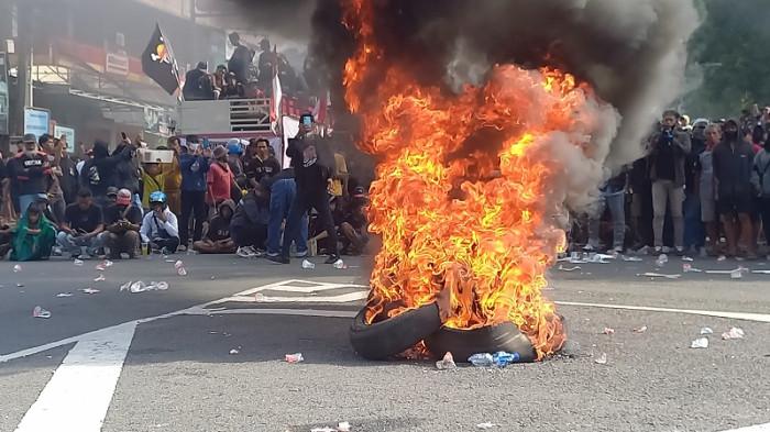 BAKAR BAN - Massa membakar ban di kawasan Alun-alun Pati sambil menunggu hasil sidang paripurna DPRD Pati terkait pemakzulan Bupati Sadewo, Jumat (31/10/2025).