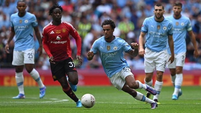 Gelandang Manchester United asal Inggris #37 Kobbie Mainoo (2L) berebut dengan gelandang Manchester City asal Norwegia #52 Oscar Bobb selama pertandingan Community Shield antara Manchester City dan Manchester United di Stadion Wembley, London pada 10 Agustus 2024. (Foto oleh JUSTIN TALLIS / AFP)