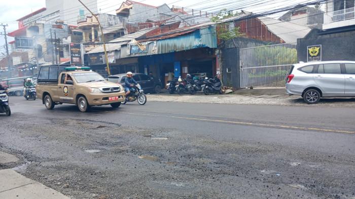 JALAN RUSAK - Titik kerusakan di Jalan Bethesda, Sario, Manado, Sulawesi Utara, Selasa (13/1/2026). Warga menyebut kerusakan semakin parah sejak akhir tahun lalu.