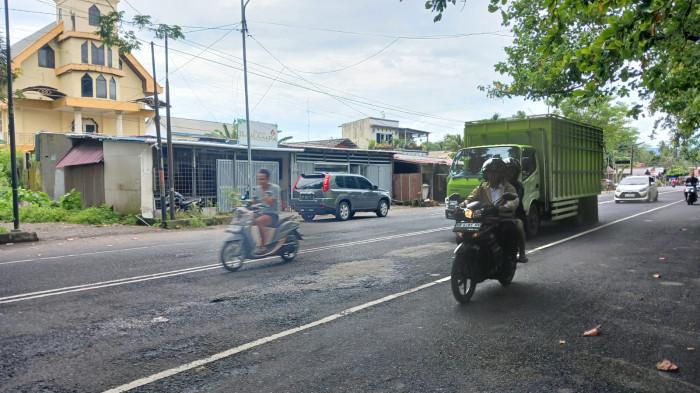 JALAN RUSAK - Kondisi jalan rusak di Boulevard II, Manado, Sulawesi Utara, Rabu (14/1/2026). Jalan tersebut hanya ditambal semen.