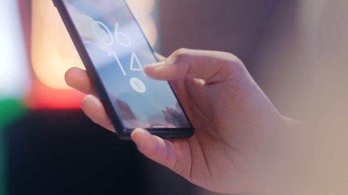 Ilustrasi seseorang yang menggunakan handphone dengan fitur sensor finger print di dalam layar.
