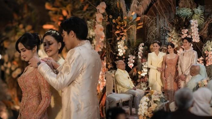 LAMARAN  - Syifa Hadju tampil sangat memukau dalam balutan kebaya modern berwarna rose gold atau terakota muda hasil karya Studio Boh. El Rumi tampak gagah mengenakan beskap berwarna krem champagne yang senada, lengkap dengan kain batik sebagai bawahan. 