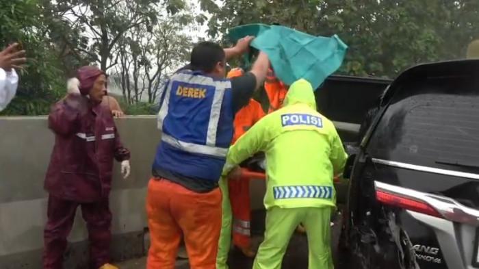 EVAKUASI - Proses evakuasi pengemudi Toyota Innova yang terlibat kecelakaan maut di Tol Cipularang KM 83 B, wilayah Jatiluhur, Kabupaten Purwakarta, Kamis (22/1/2026). Pengemudi dilaporkan meninggal dunia dalam perjalanan ke rumah sakit saat hujan deras mengguyur lokasi kejadian.