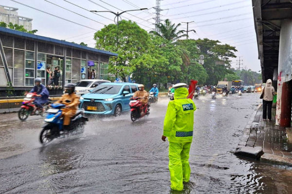 Polisi memantau arus lalu lintas di jalanan yang tergenang banjir di kawasan Daan Mogot, Jakarta Barat, Kamis (22/1/2026). Foto: Dok. Istimewa