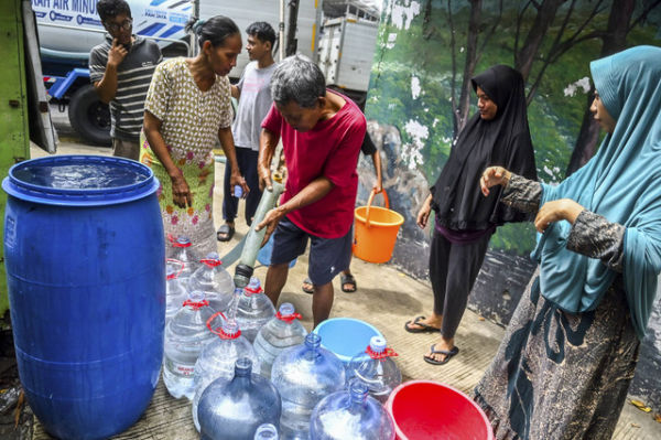 Warga antre untuk mengambil bantuan air bersih di kawasan Lodan, Pademangan, Jakarta, Rabu (18/12/2024). Foto: Rivan Awal Lingga/ANTARA FOTO