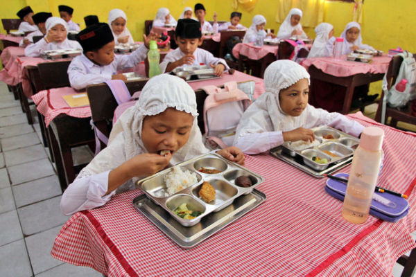 Siswa menyantap makan bergizi gratis di Sekolah Madrasah Ibtidaiyah Negeri Medan, Sumatera Utara, Rabu (14/1/2026). Foto: Yudi Manar/ANTARA FOTO 