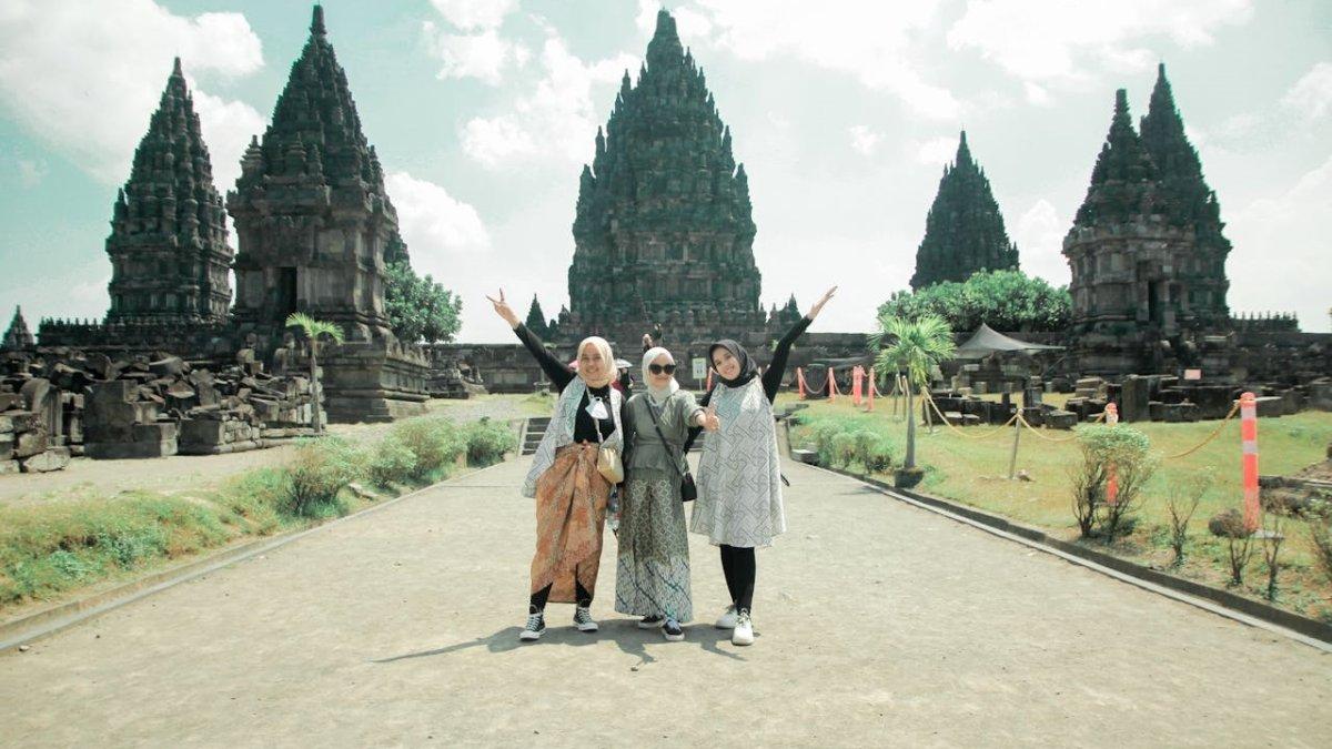 CANDI PRAMBANAN JOGJA - Wisatawan yang sedang berpose dengan latar belakang Candi Prambanan. 