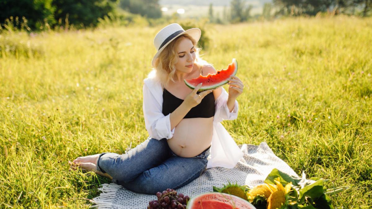 Ilustrasi ibu hamil yang mengonsumsi buah semangka, kenali ragam manfaat buah untuk kehamilan