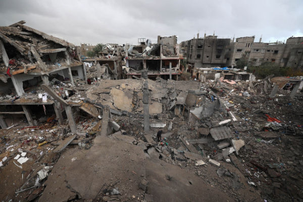 Seorang pria berjalan di tengah reruntuhan di kamp Bureij di Jalur Gaza tengah, Jumat (9/1/2026). Foto: EYAD BABA/AFP