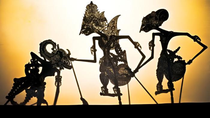 WAYANG KULIT- Ilustrasi pertunjukan wayang kulit yang merupakan kesenian masyarakat Jawa. Pertunjukan ini sebagai hiburan yang berisi pesan moral.