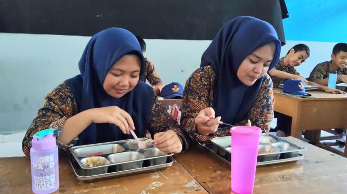 MBG SMP - Murid saat menyantap menu MBG di SMPN 6 Topoyo, Desa Topoyo, Kecamatan Topoyo, Kabupaten Mamuju Tengah, Sulawesi Barat, Kamis (2/10/2025). Mereka sangat lahap memakan MBG tersebut. (Sandi/Tribun)