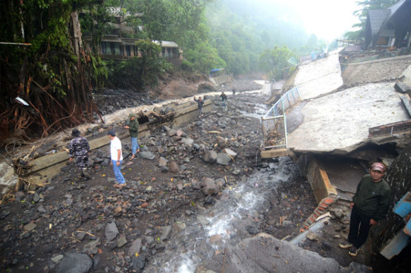 Warga berada di dekat bangunan yang rusak diterjang banjir bandang di Obyek Wisata Guci, Kabupaten Tegal, Jawa Tengah, Minggu (25/1/2026). Foto: Oky Lukmansyah/ANTARA FOTO