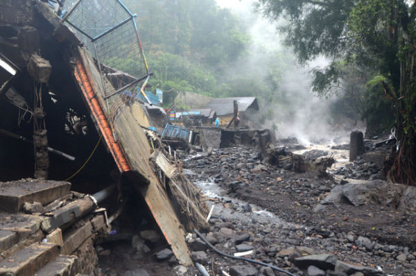 Warga berada samping bangunan yang rusak diterjang banjir bandang di Obyek Wisata Guci, Kabupaten Tegal, Jawa Tengah, Minggu (25/1/2026). Foto: Oky Lukmansyah/ANTARA FOTO