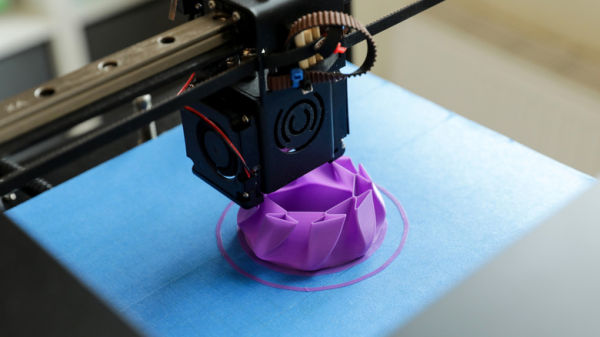 A 3D printer creating a purple object.