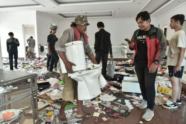 Sejumlah massa tidak dikenal membawa barang-barang di rumah Anggota DPR Surya Utama atau Uya Kuya di Pondok Bambu, Jakarta Timur, Minggu (31/8/2025). Foto: Fakhri Hermansyah/ANTARA FOTO