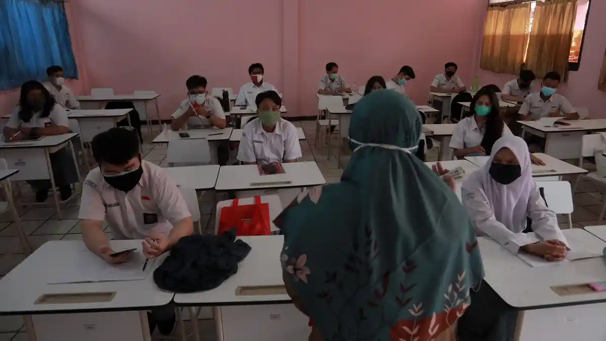 KUNCI JAWABAN BAHASA INDONESIA - Guru memberikan pembelajaran kepada siswa saat uji coba pembelajaran tatap muka terbatas di SMA Negeri 1 Tangerang, Banten, Senin (6/9/2021). Simak kunci jawaban Bahasa Indonesia Kelas 12 Halaman 200 Bab 6 terdapat tugas membuat kalimat kritik dalam kutipan novel Laskar Pelangi. 