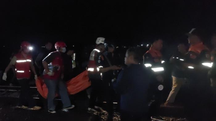 EVAKUASI - Petugas mengevakuasi korban meninggal pasca truk tertemper kereta api di perlintasan JPL 582 Desa Mekarsari, Kecamatan Kutowinangun, Kabupaten Kebumen, Selasa (27/1/2026) malam.