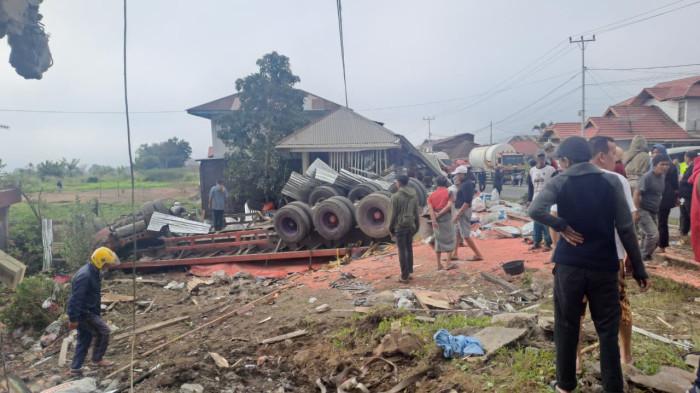 KECELAKAAN BERUNTUN - Warga menyaksikan kondisi sebuah truk yang terbalik dan menabrak bangunan di kawasan Panyalaian, Kecamatan Sepuluh Koto, Kabupaten Tanah Datar, Sumatera Barat, Senin (26/1/2026). Kecelakaan beruntun yang diduga dipicu rem blong tersebut melibatkan sejumlah kendaraan dan menyebabkan kerusakan parah di lokasi kejadian.