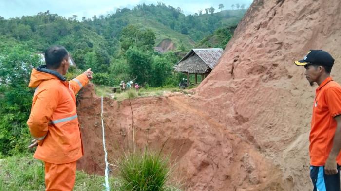 Pantau Longsor - Dua petugas sedang memantau area yang tertimpa longsor di di Kabupaten Mamasa, Sulawesi Barat tepatnya di Dusun Salukatambi, Desa Penatangan, Kecamatan Buntumalangka, abut (13/12/2025).