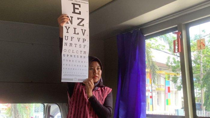 LAYANAN SIM KELILING – Petugas SIM Keliling melakukan tes visus mata terhadap pemohon sebagai salah satu persyaratan perpanjangan Surat Izin Mengemudi (SIM), Rabu (14/1/2026).