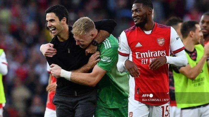 Manajer Arsenal asal Spanyol Mikel Arteta (kiri) dan penjaga gawang Arsenal asal Inggris Aaron Ramsdale (kedua dari kiri) merayakan kemenangan mereka dalam pertandingan sepak bola Liga Inggris antara Arsenal dan Tottenham Hotspur di Stadion Emirates di London pada 26 September 2021. Arsenal memenangkan pertandingan ke-3 -1.