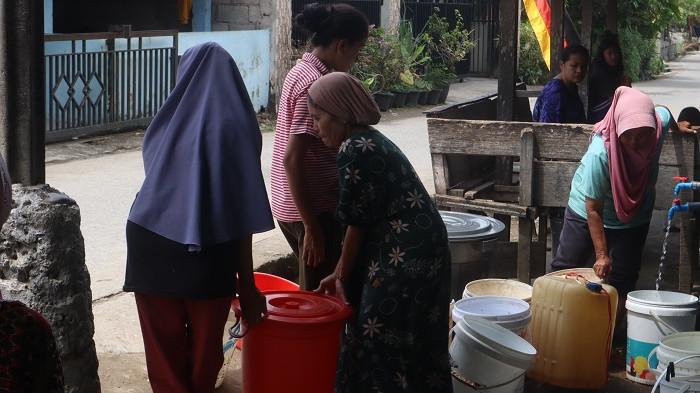 KEKERINGAN DI PADANG: Warga Kelurahan Pasa Ambacang, Kecamatan Kuranji, Kota Padang antre air bersih, Selasa (27/1/2026). Sejak akhir tahun lalu, sumur-sumur yang selama puluhan tahun menghidupi mereka mendadak bungkam, menyisakan lubang tanah yang tandus dan berdebu.